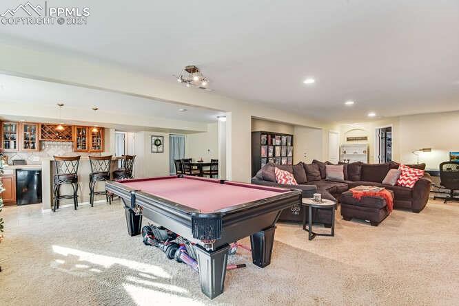 13873 Windy Oaks Road Colorado Springs, CO 80921 - Photo 26 of 28 a living room with furniture a pool table and a fireplace