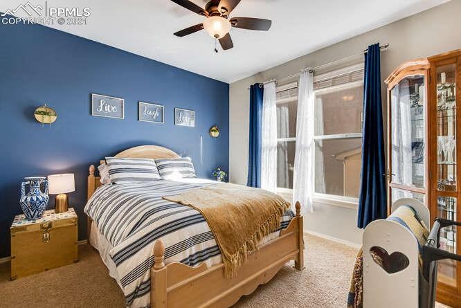 13873 Windy Oaks Road Colorado Springs, CO 80921 - Photo 5 of 28 a bedroom with a bed and a chandelier