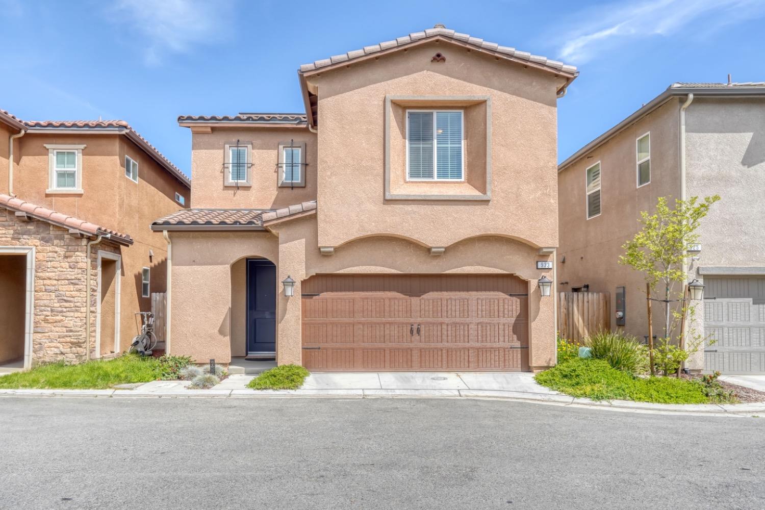 933 Winchell Way West Madera, CA 93636 - Photo 1 of 29 a front view of a house with a yard and garage