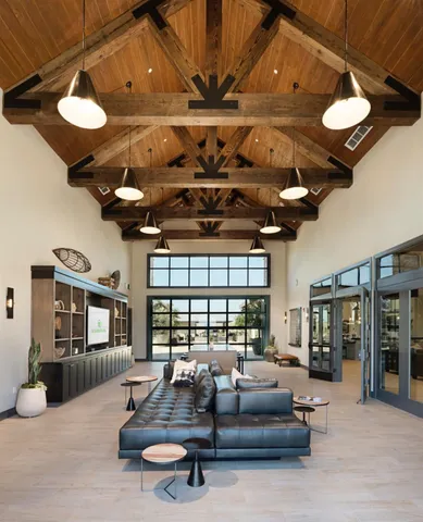a living room with furniture a chandelier and a large window