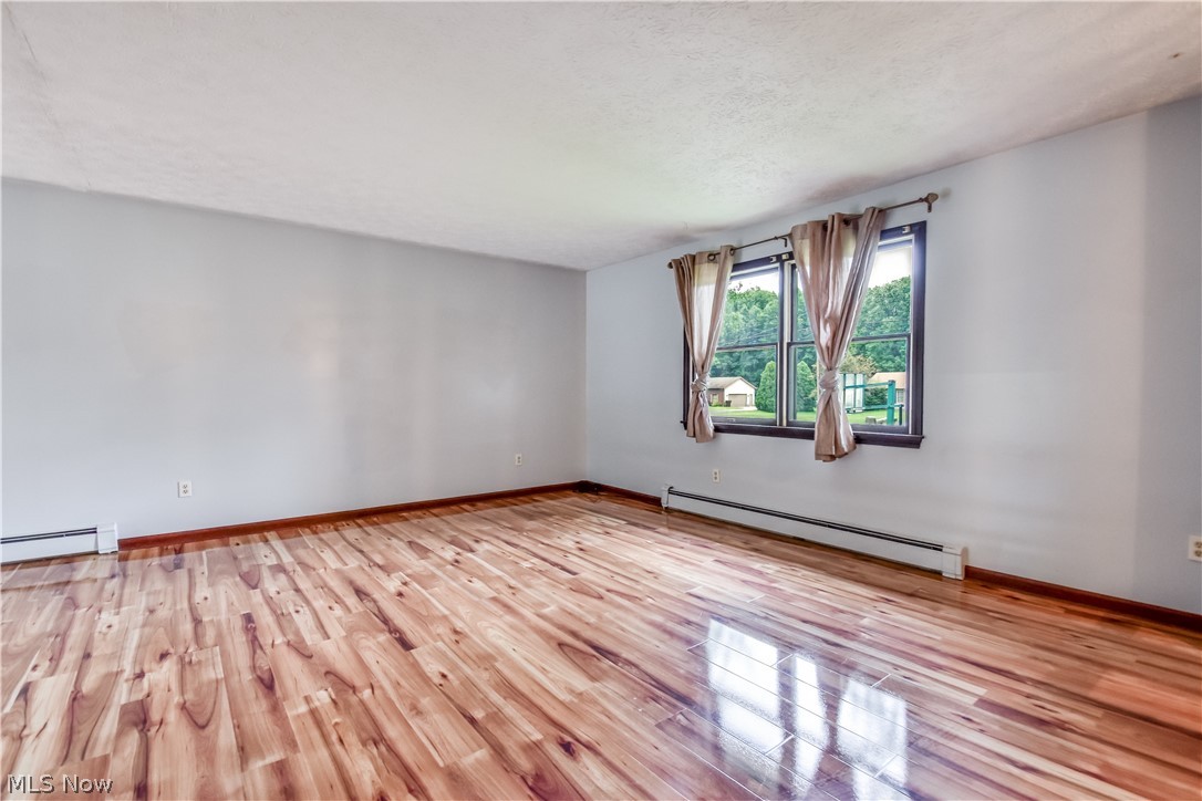 6487 Shaffer Road Northwest Warren, OH 44481 - Photo 3 of 44 Spacious room featuring wood-finish flooring, light grey walls, and two large windows with dark trim
