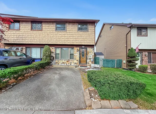 a backyard of a house with plants and outdoor seating