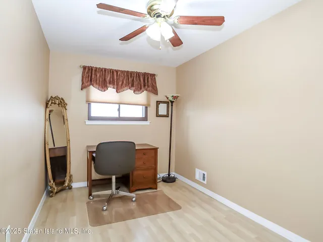a view of a workspace with furniture and a window