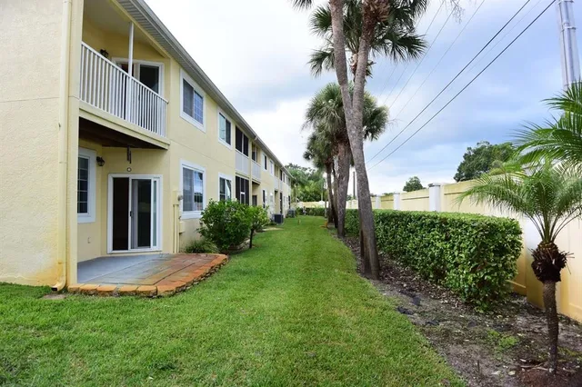 a view of a house with a yard and potted plants