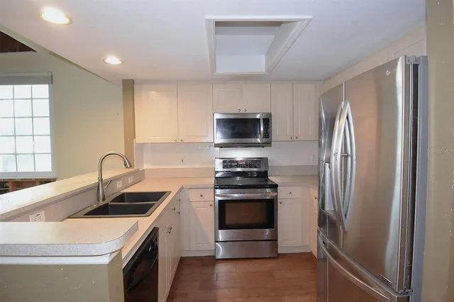 a kitchen with stainless steel appliances granite countertop a refrigerator sink and stove