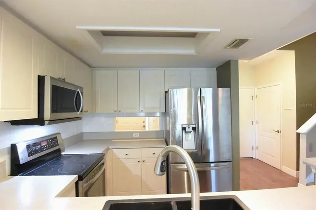a kitchen with stainless steel appliances a refrigerator a stove a microwave and cabinets