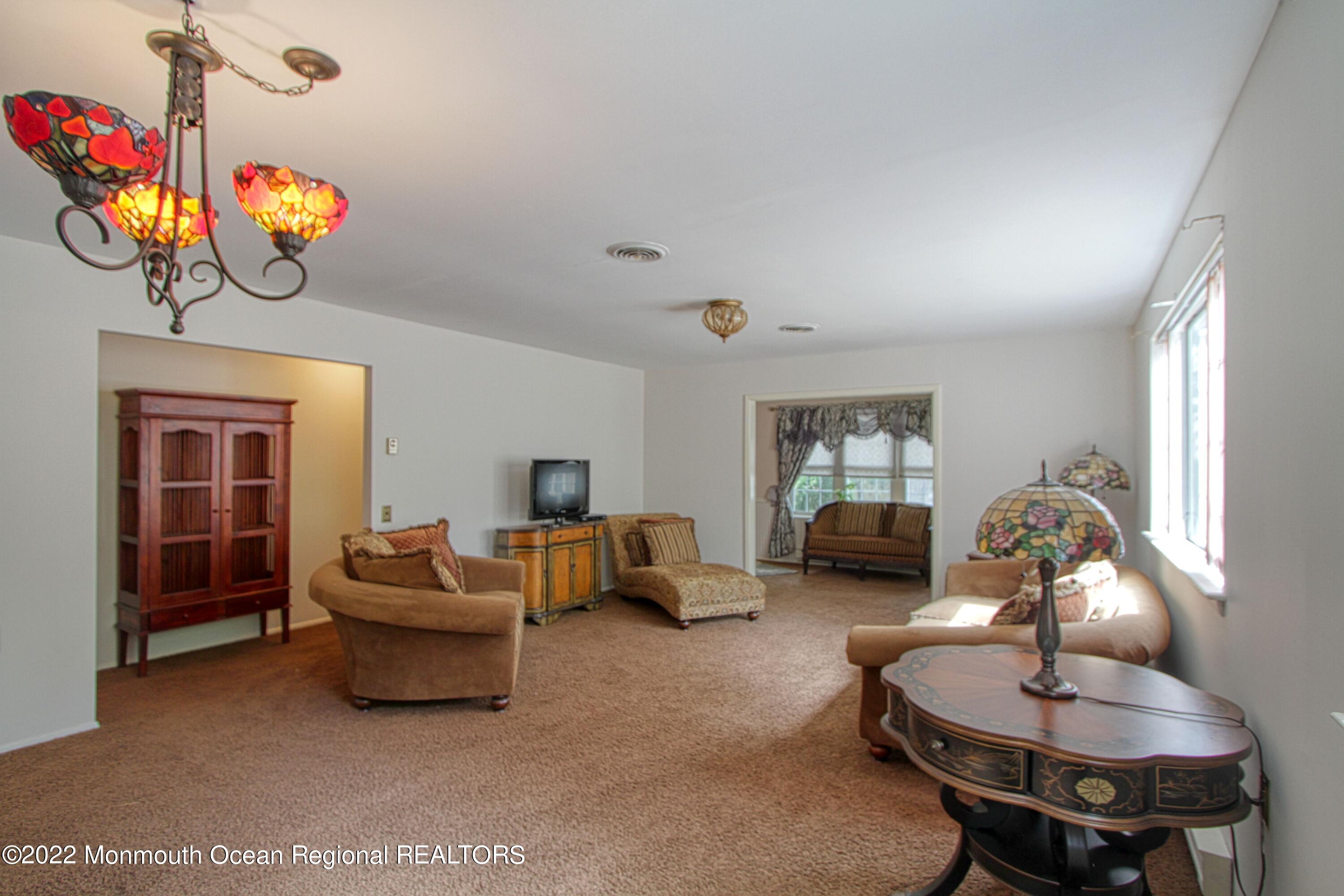 8A Fallbrook Street, Unit A Whiting, NJ 08759 - Photo 7 of 18 a living room with furniture a chandelier and a window