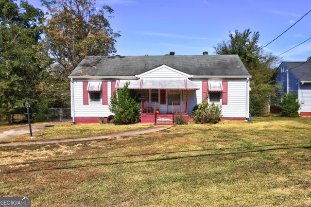 a porch with a table and chairs under an umbrella