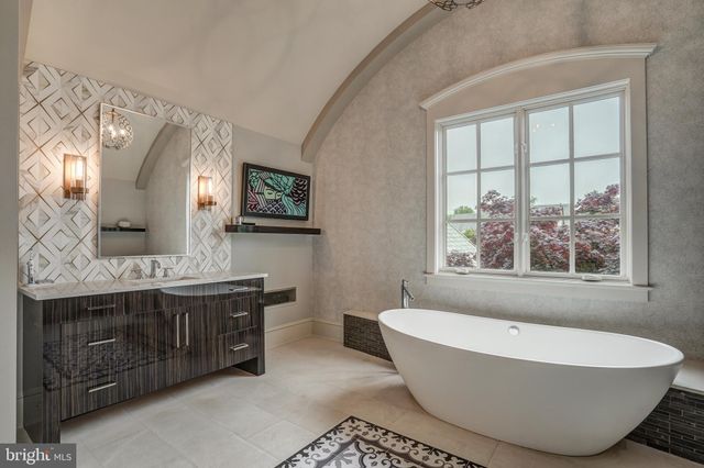 a spacious bathroom with a double vanity sink mirror and bathtub