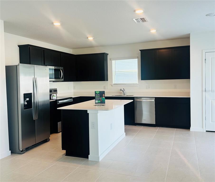 3669 Hornbeam Road Spring Hill, FL 34609 - Photo 4 of 4 a kitchen with a refrigerator and a microwave