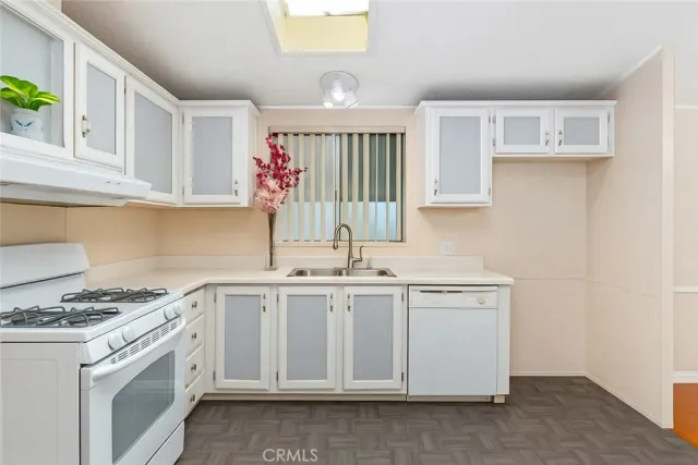 a kitchen with stainless steel appliances granite countertop a sink stove and cabinets