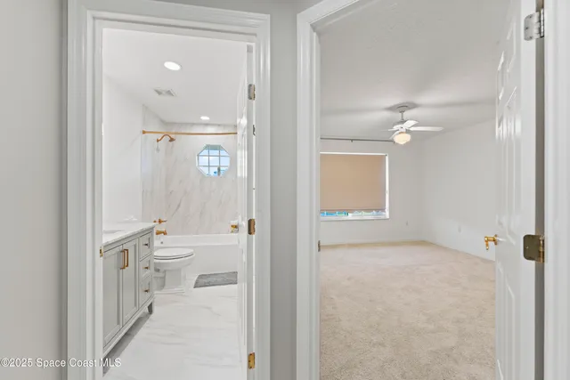 a big yard with large trees and cars parked in front of it