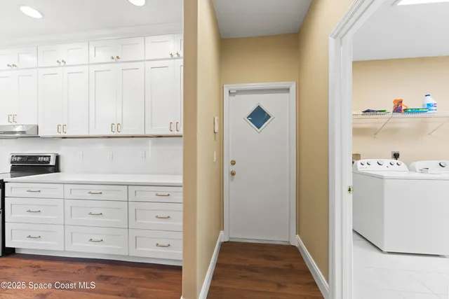 a large kitchen with stainless steel appliances kitchen island a large counter top and a wooden floors