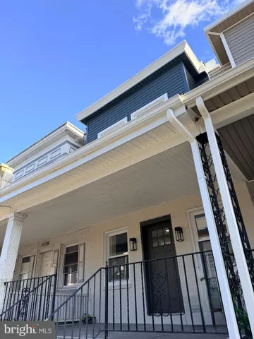 a view of an empty room with wooden floor and stairs
