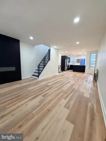 a living room with stainless steel appliances kitchen island hardwood floor and a window