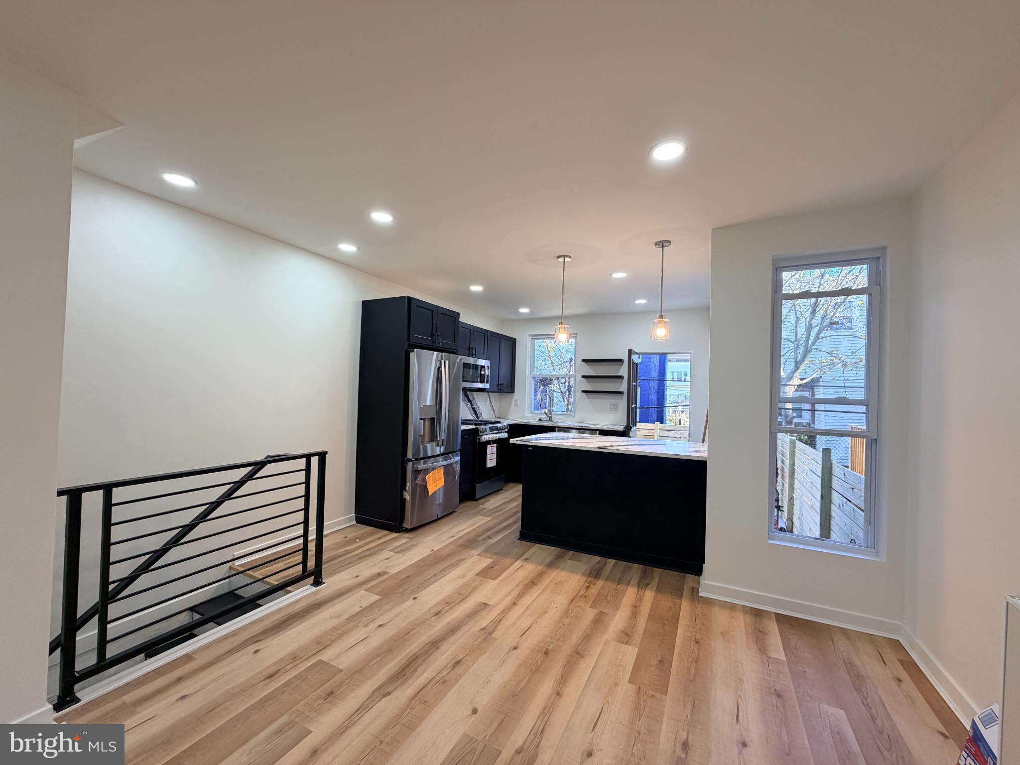 5436 Ridgewood Street Philadelphia, PA 19143 - Photo 4 of 30 a living room with stainless steel appliances kitchen island hardwood floor and a window