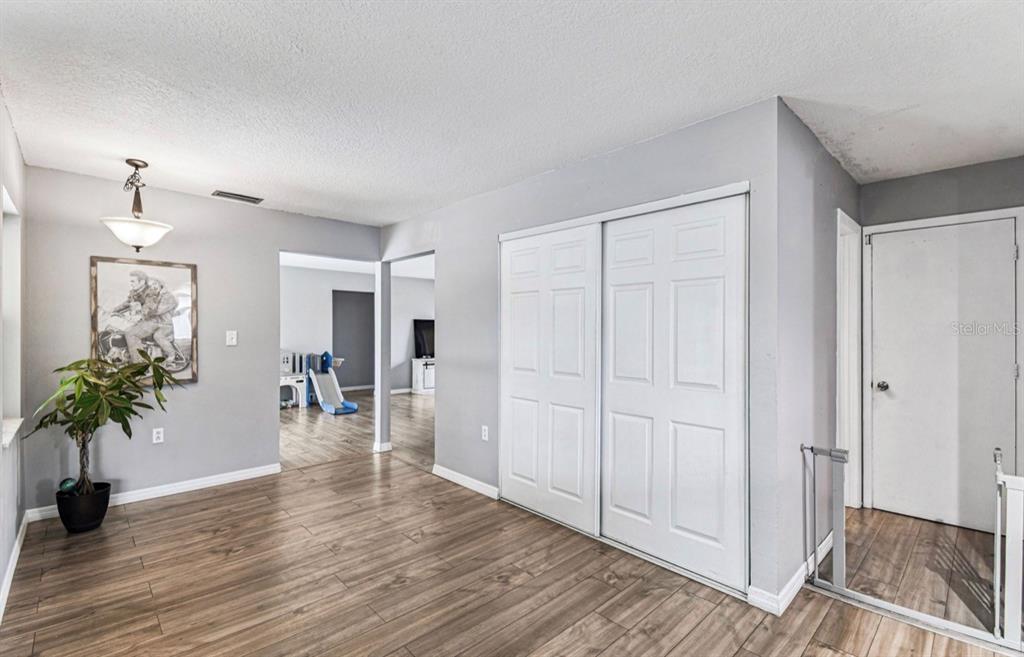 7112 Vista Way New Port Richey, FL 34653 - Photo 16 of 54 a view of a hallway with wooden floor and a potted plant