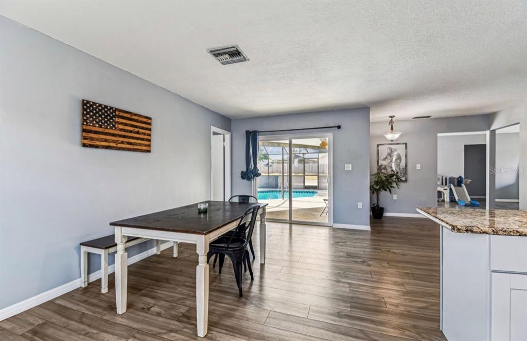 7112 Vista Way New Port Richey, FL 34653 - Photo 28 of 54 a view of a dining room with furniture and wooden floor