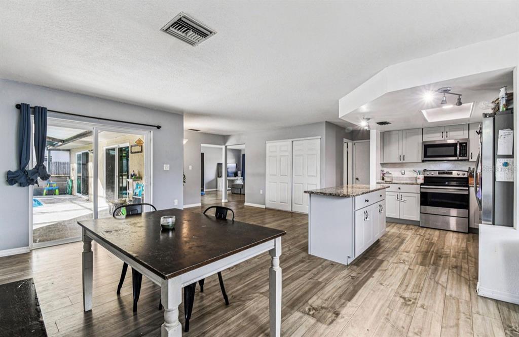 7112 Vista Way New Port Richey, FL 34653 - Photo 29 of 54 a kitchen with stainless steel appliances granite countertop a sink refrigerator and cabinets