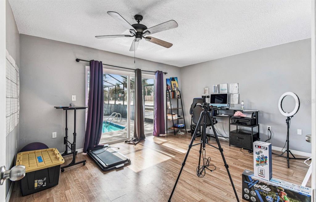 7112 Vista Way New Port Richey, FL 34653 - Photo 32 of 54 a living room with furniture a flat screen tv and a floor to ceiling window