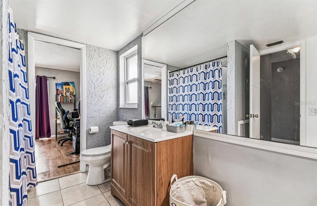 7112 Vista Way New Port Richey, FL 34653 - Photo 35 of 54 a spacious bathroom with a granite countertop sink a toilet a mirror and shower