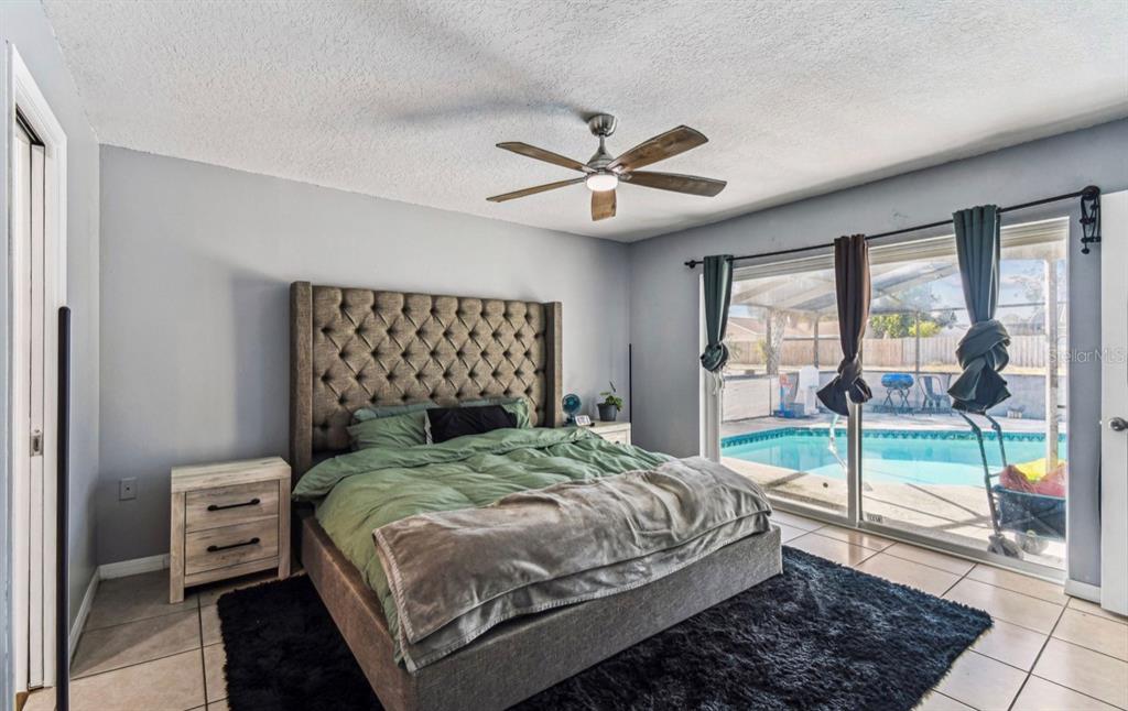 7112 Vista Way New Port Richey, FL 34653 - Photo 40 of 54 a bedroom with a large bed and a chandelier