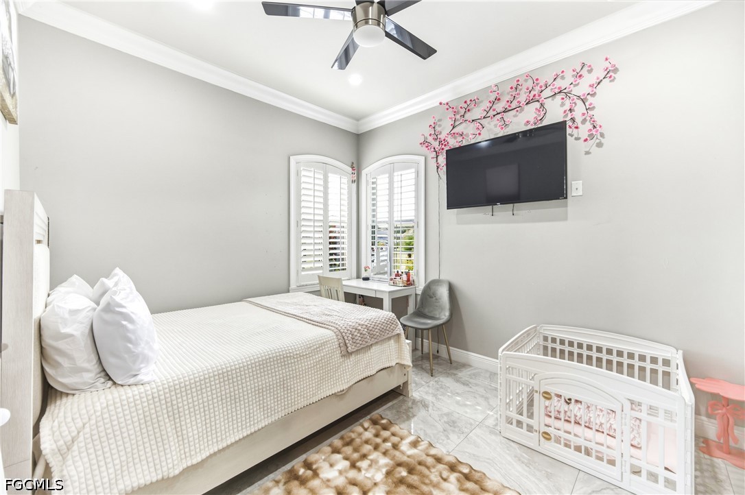 1700 43rd Terrace Southwest Naples, FL 34116 - Photo 14 of 38 a bedroom with a bed and a television