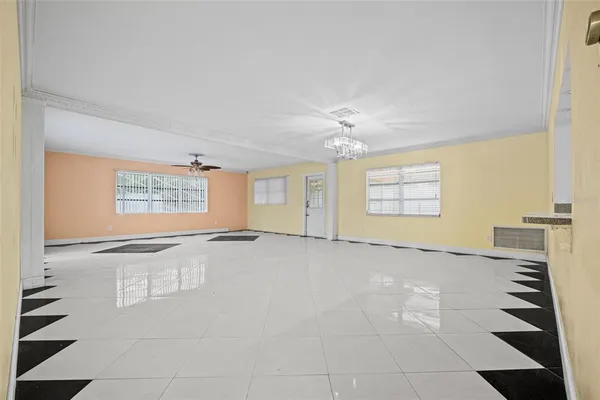 an empty room with windows and chandelier