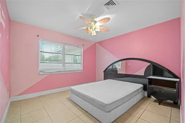 a view of an empty room with chandelier fan