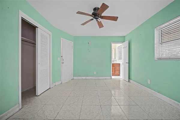 a view of an empty room with closet and a chandelier fan