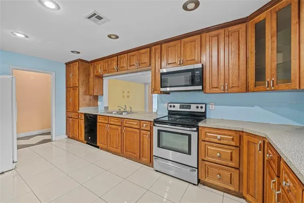 a kitchen with stainless steel appliances granite countertop a stove microwave and sink
