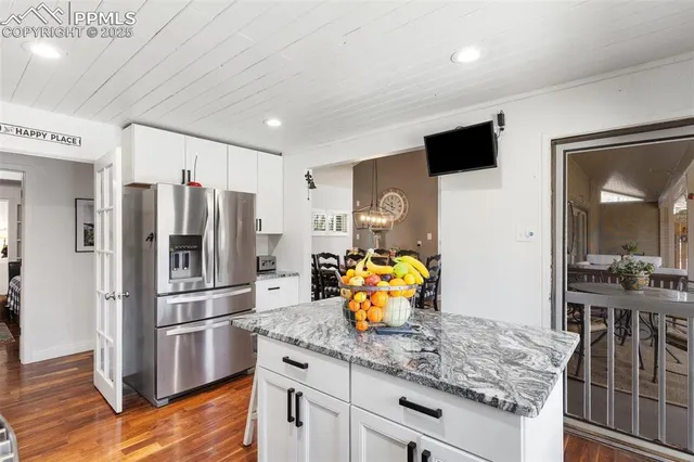 a kitchen with stainless steel appliances granite countertop a refrigerator and a stove