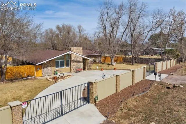 a view of a roof deck with couches and wooden fence