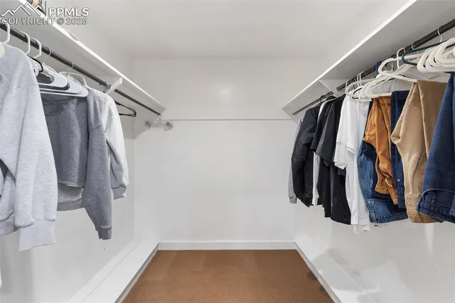 a view of walk in closet with clothes and shoes