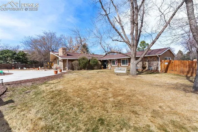 a front view of a building with large trees