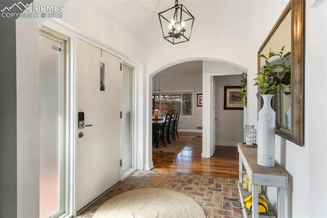 a view of a livingroom with wooden floor and a chandelier
