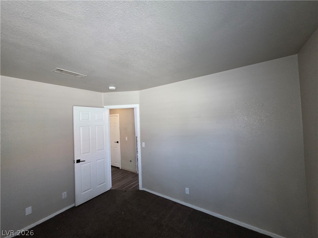 2275 Ramsgate Drive Henderson, NV 89074 - Photo 76 of 84 A well-proportioned bedroom with new carpet and easy access to an adjacent room, ready for personalization.