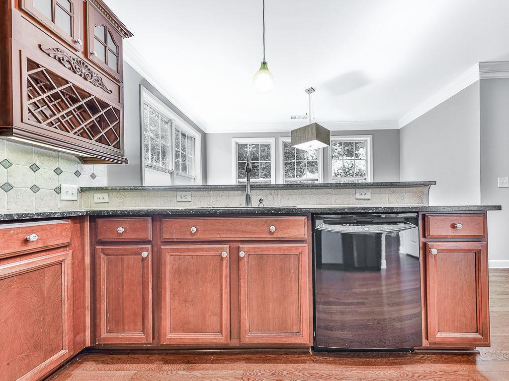 626 Laurel Crossing Canton, GA 30114 - Photo 24 of 77 a kitchen with stainless steel appliances granite countertop a stove and a sink