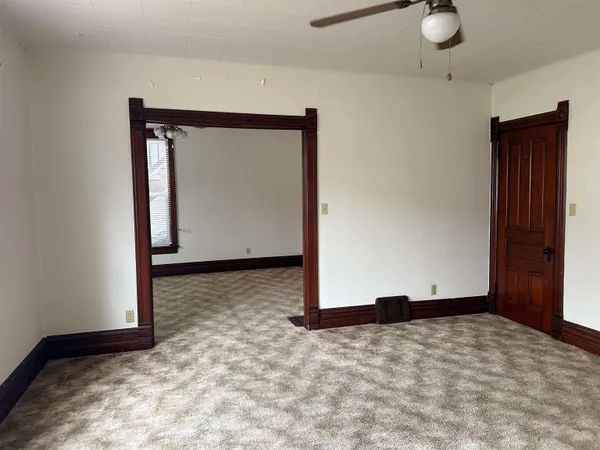 a view of an empty room with closet and a window