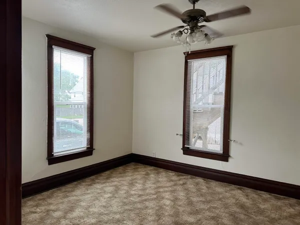 a view of empty room with windows and ceiling fan