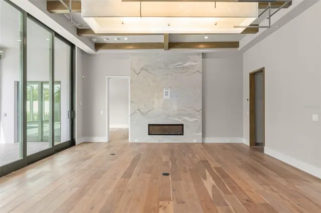 a view of a hallway with wooden floor and a fireplace