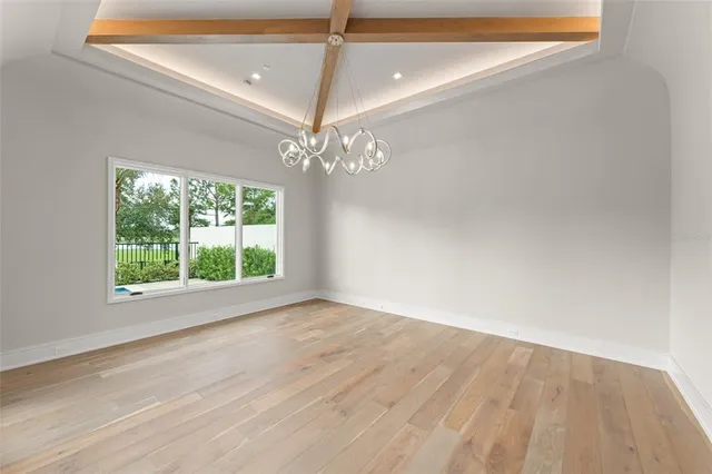 a view of a room with wooden floor and chandelier