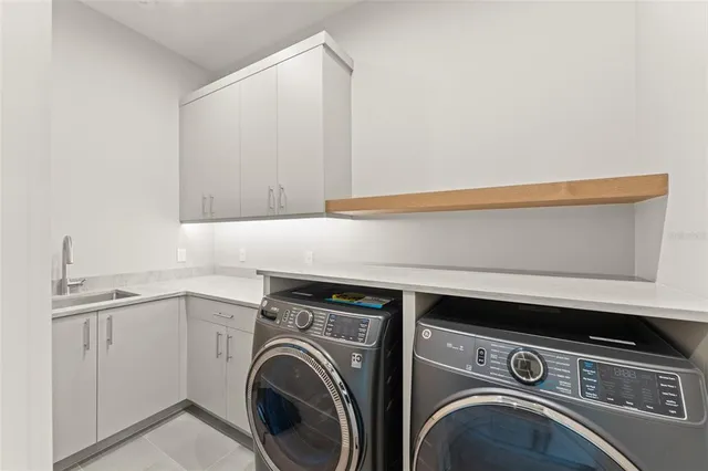a utility room with sink dryer and washer