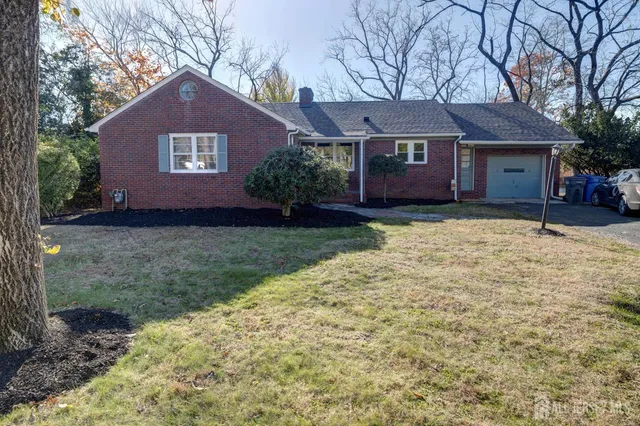 a front view of a house with yard and trees