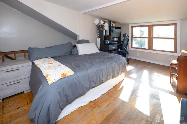 a bedroom with a bed and wooden floor