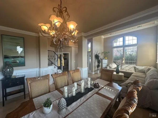 a living room with furniture a chandelier and a large window