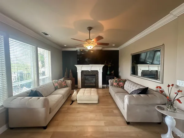 a living room with furniture a fireplace and a large window