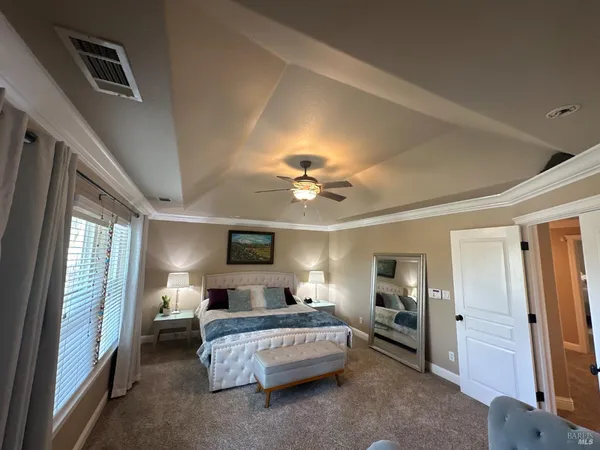 a spacious bedroom with a bed and a chandelier