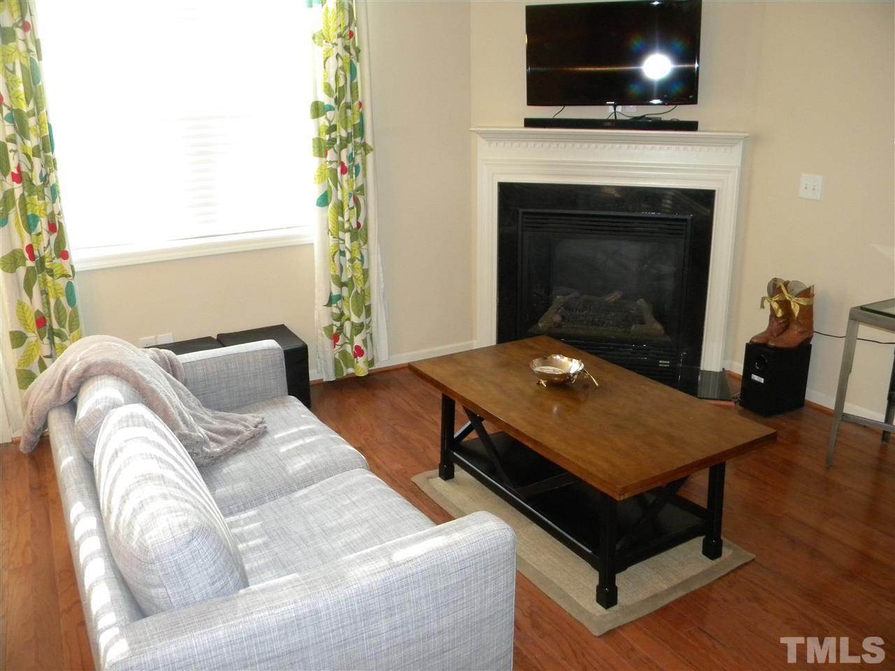 4608 Altha Street Raleigh, NC 27606 - Photo 4 of 12 a living room with a flat screen tv and a fireplace