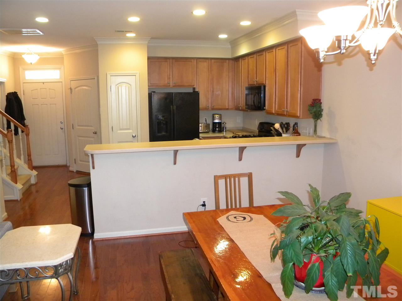 4608 Altha Street Raleigh, NC 27606 - Photo 7 of 12 a kitchen with stainless steel appliances granite countertop a refrigerator a sink a stove and white cabinets with wooden floor